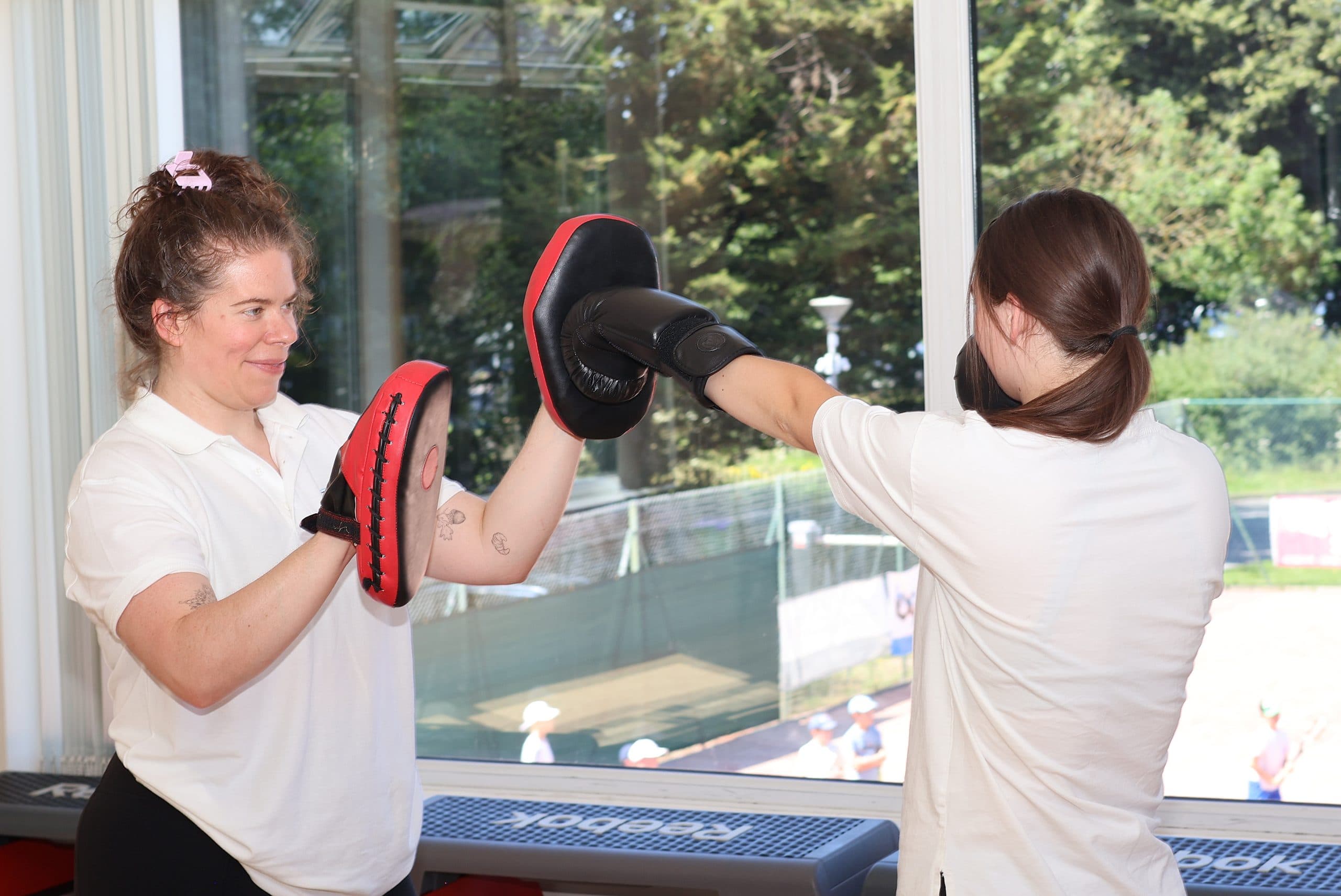 One person holds focus mitts while another practises a punch