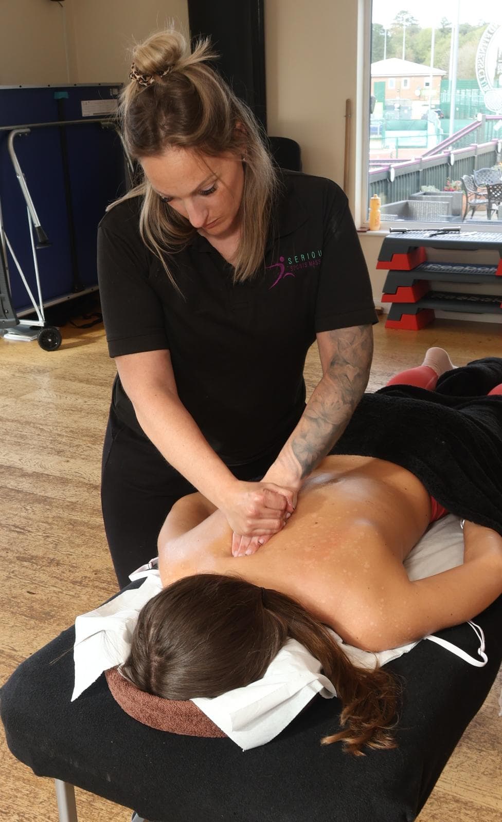 A practitioner applies a hands-on technique to a person's upper back